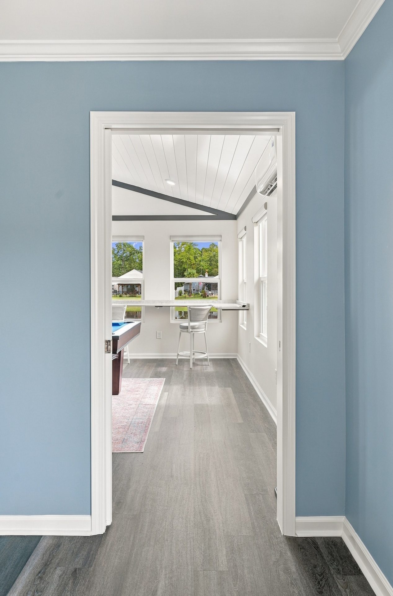 Glass-panel door open from the main hallway into the sunroom addition