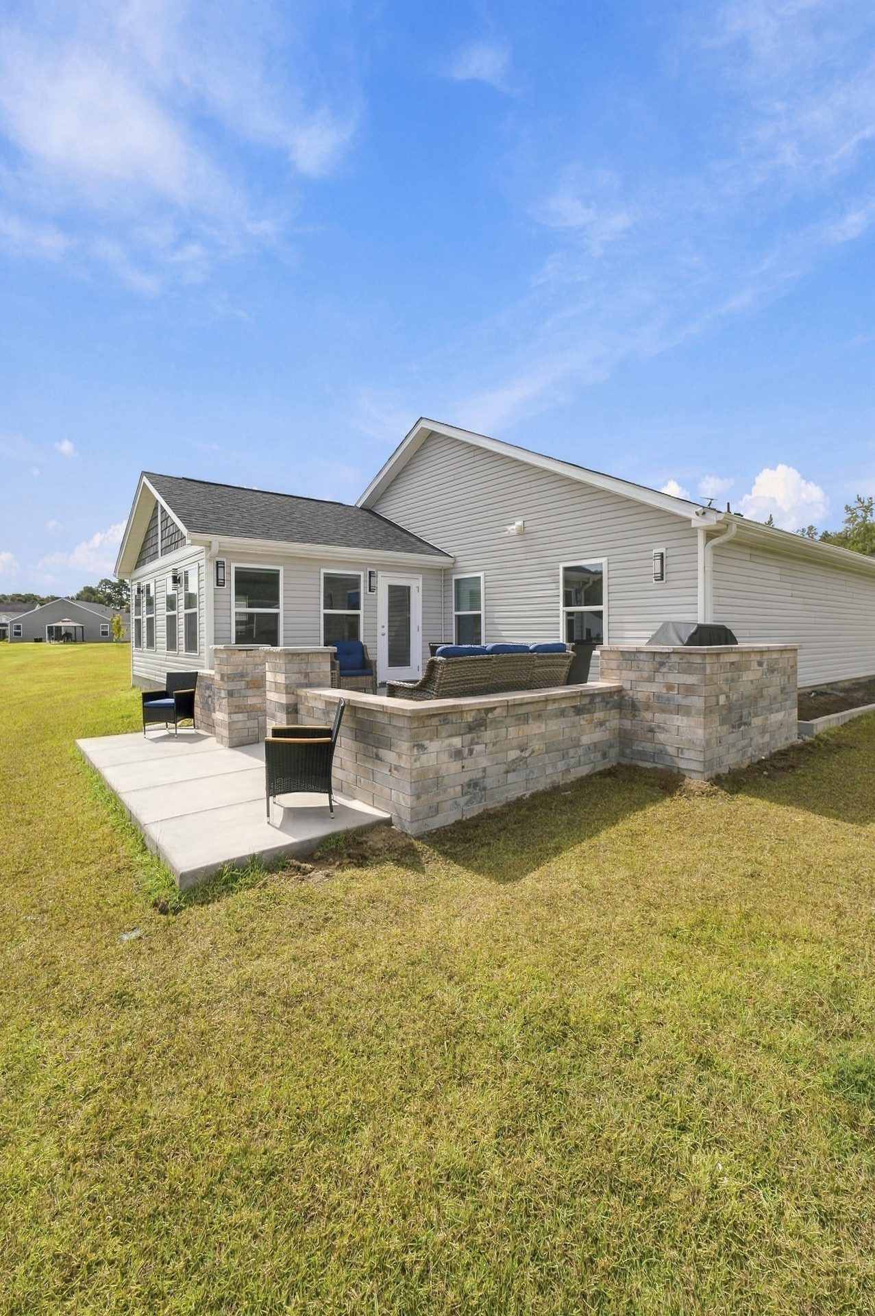 Stacked-stone seat walls and columns framing the patio, seen from the lawn