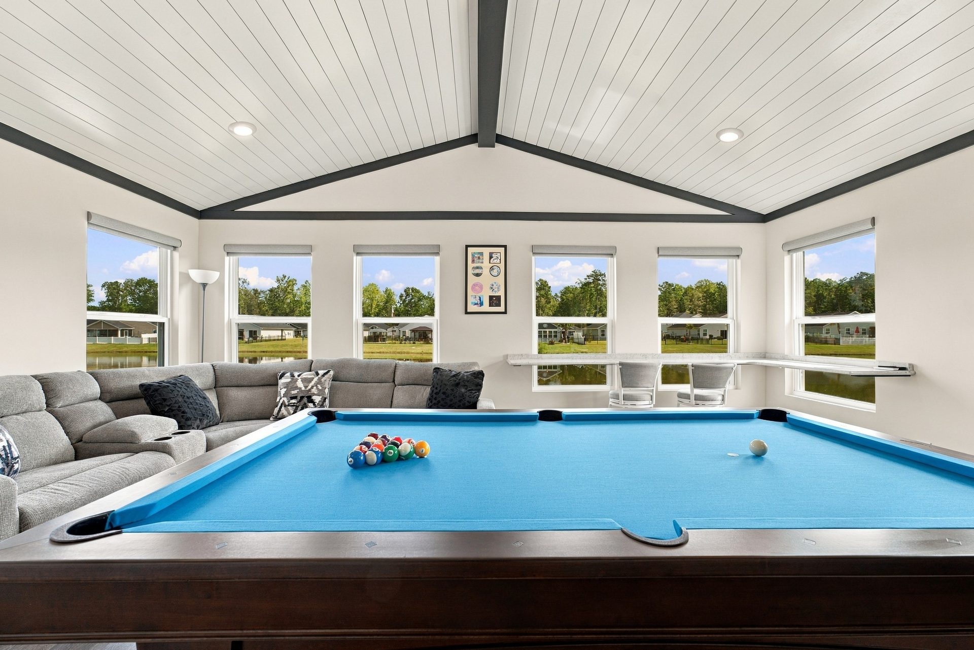 Sunroom interior looking across the seating area to the window wall and the view beyond