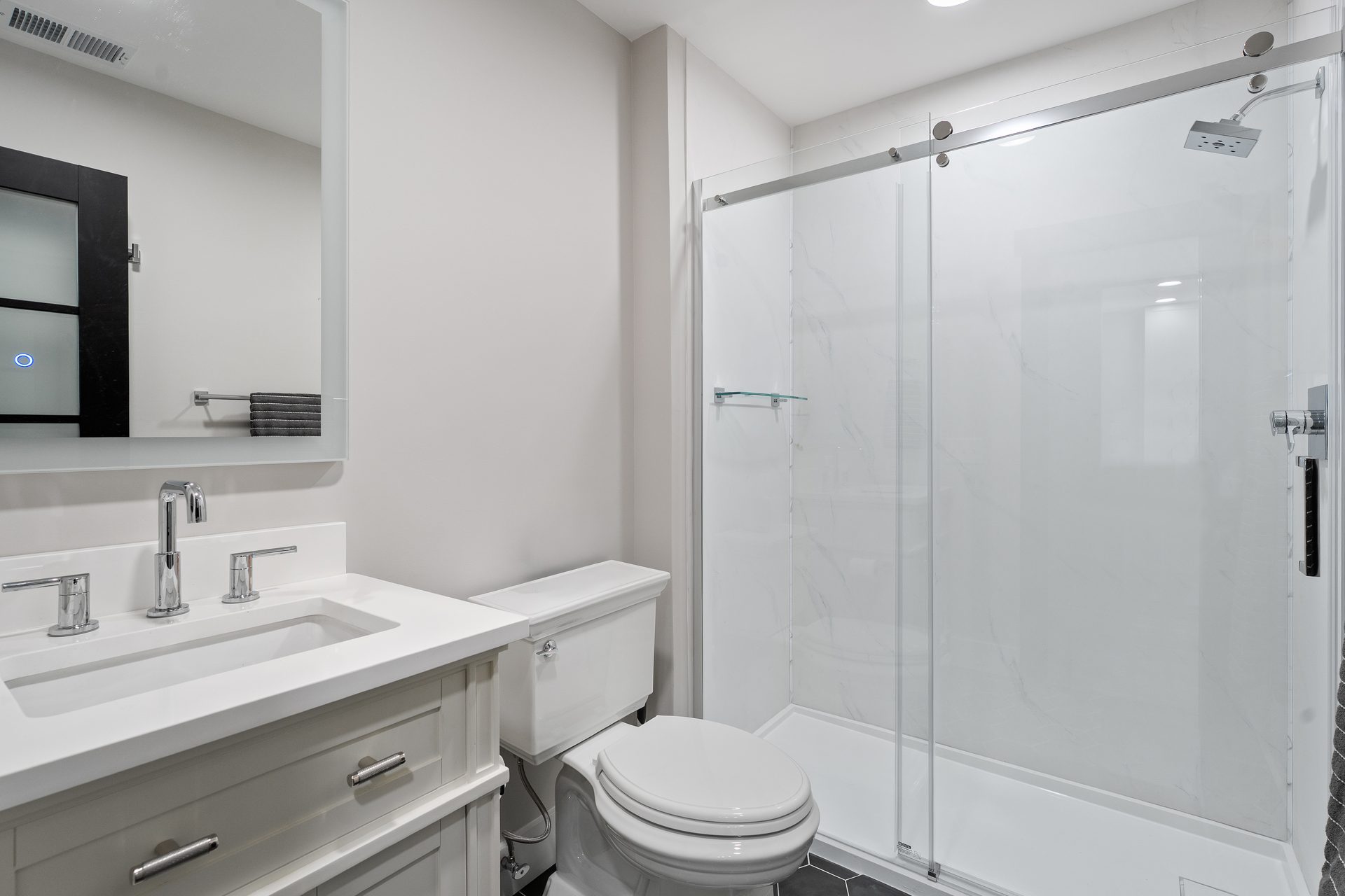 Walk-in shower with frameless sliding glass door and tile surround