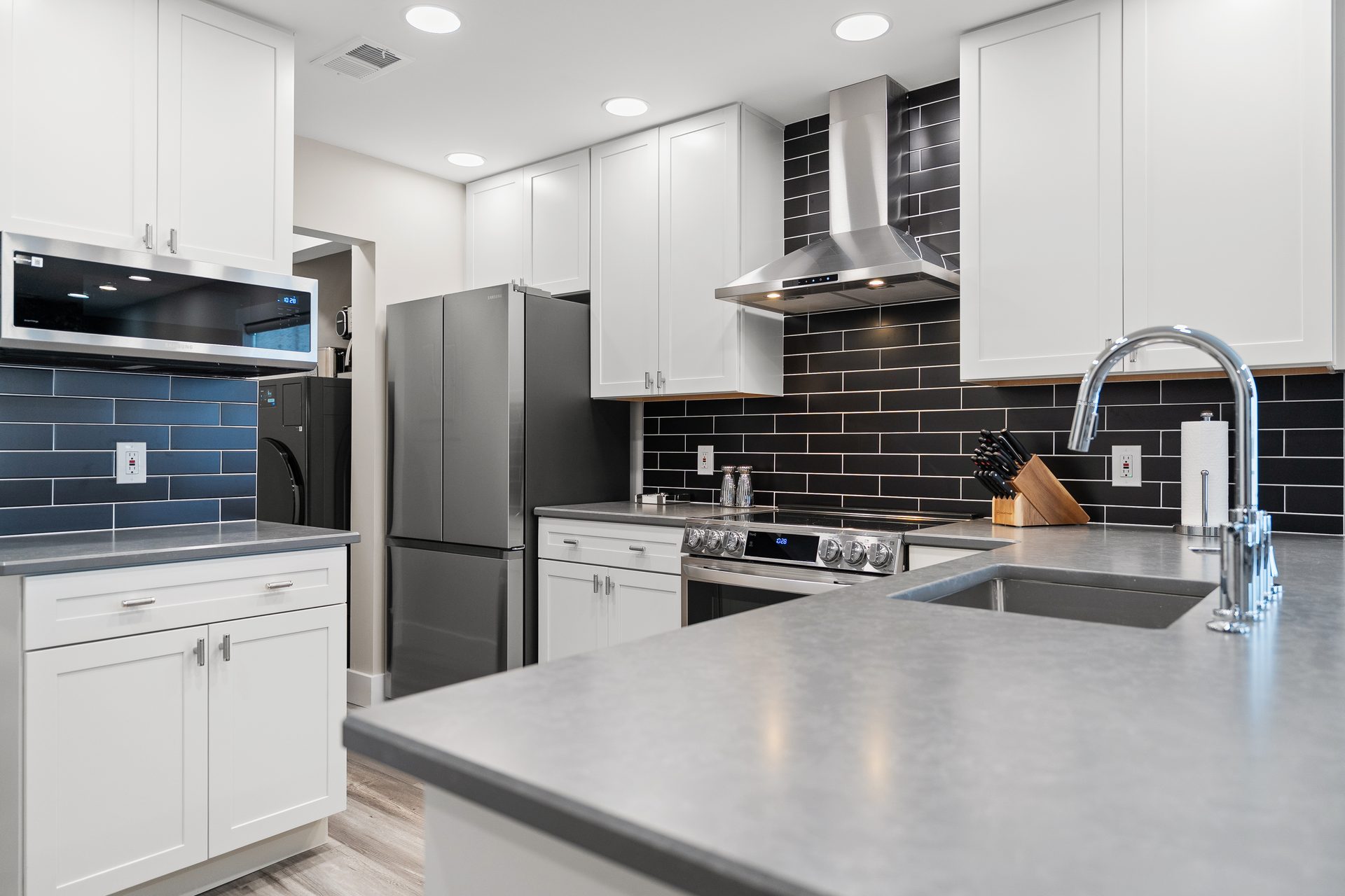 Kitchen peninsula with quartz countertop, undermount sink and pull-down faucet after renovation
