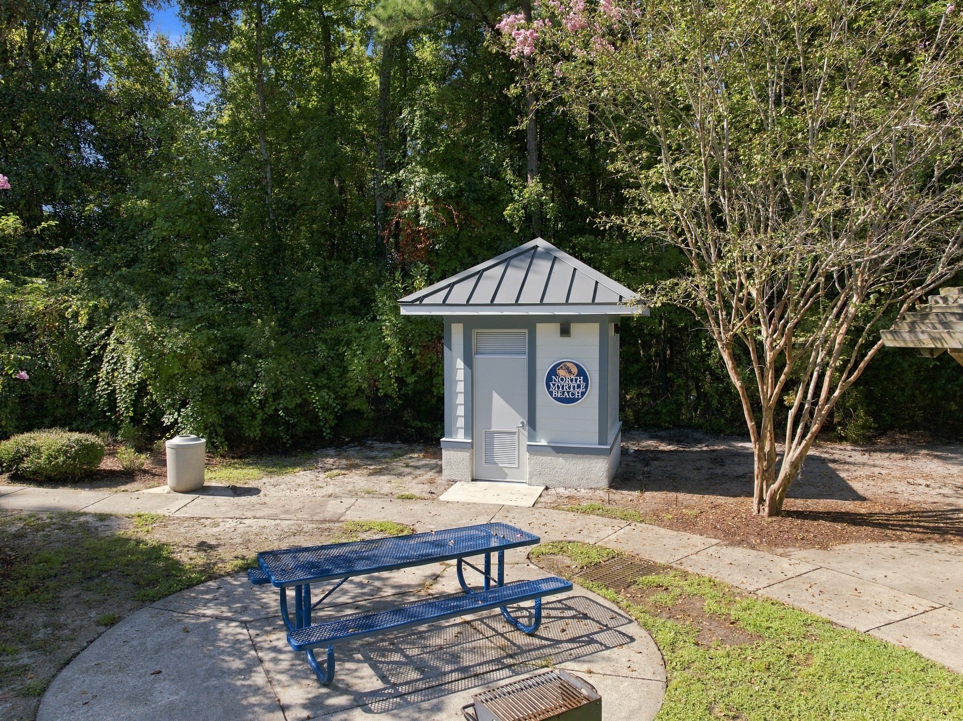 Public restroom building in a North Myrtle Beach city park, seen from above with the picnic area and walking path beside it