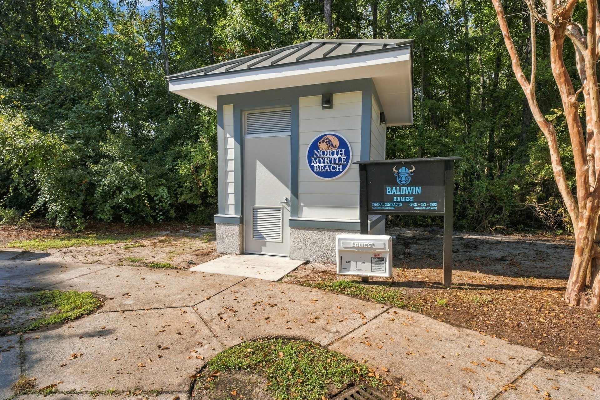 Entry side of the city restroom building, with the louvered vent, the city seal and the walkway leading to the door
