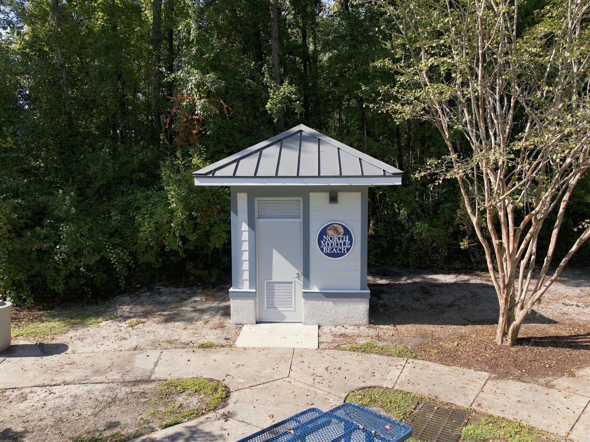 Front of the city restroom building, showing the standing-seam metal roof and the City of North Myrtle Beach seal